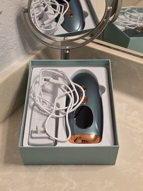 Handheld Pulsed Light Hair Removal Device in Teal and Rose Gold
